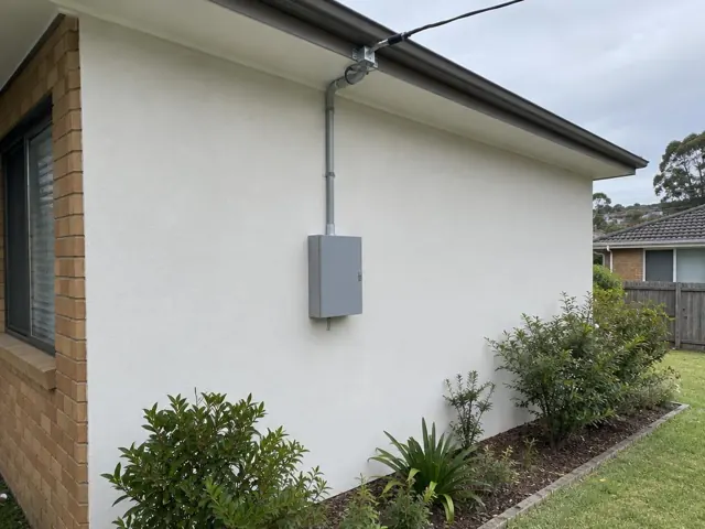 Overhead service cable and point-of-attachment bracket on a house exterior wall in Rathmines